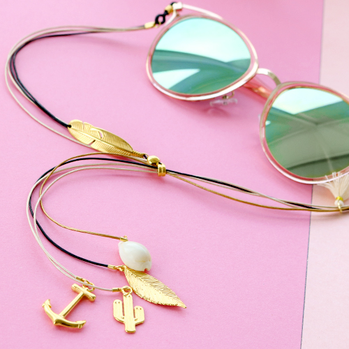 Sommer Sonnenbrillenkordel mit goldenen Details und minimalistischen Ohrringen aus Stainless Steel.